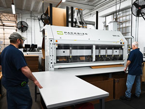 Two IPI associates operating a packaging fabrication machine at Anamosa State Penitentiary