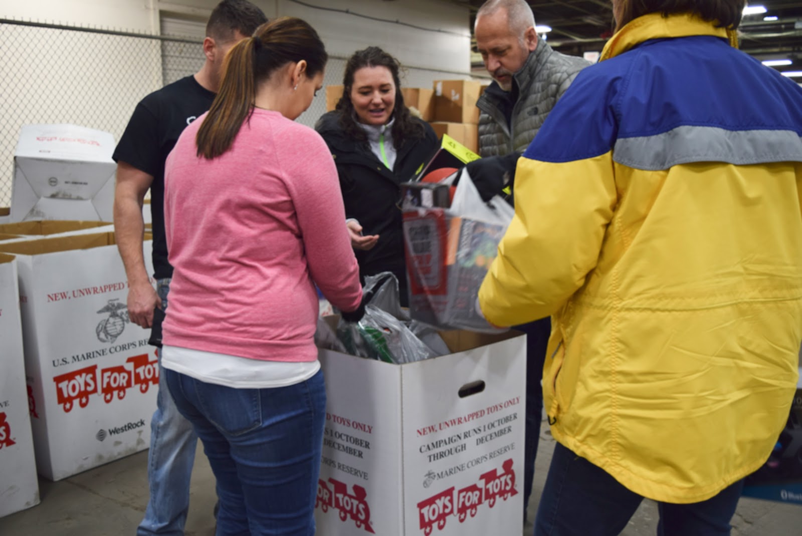 IPI staff at the donation location placing bags of toys into the donation bins