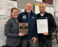 Kevin Peterson standing in between Sales & Marketing Manager Ann Baughman (Left) and IPI Director Bob Fairfax (Right) while wearing his IPI Change Champion Jacket. 