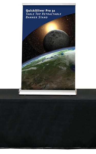 Tabletop retractable banner stand with space graphics displayed on a black table