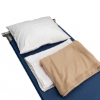 White pillow, flat sheets, and a tan fleece blanket layed out on a blue cot bed