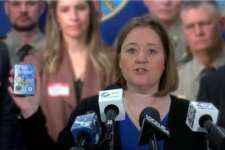 Iowa Attorney General Brenna Bird holding a deck of Iowa cold case playing cards during her press conference.