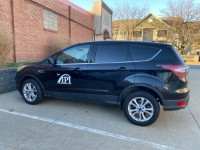 Black SUV in the IPI Showroom parking lot with a white IPI decal on the driver's side door.