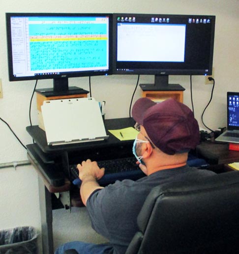 Photo of inmate transcribing materials into braille