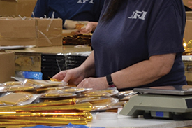Inmate packing golden balloons into boxes